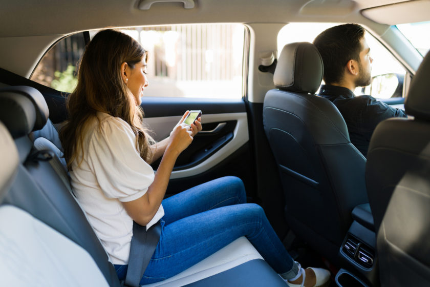 Avoid Conversation With Your Rideshare Driver - Female passenger texting in the car